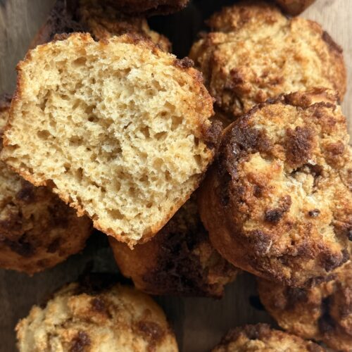 Cinnamon roll protein pancake muffins topped with cream cheese glaze on a cooling rack