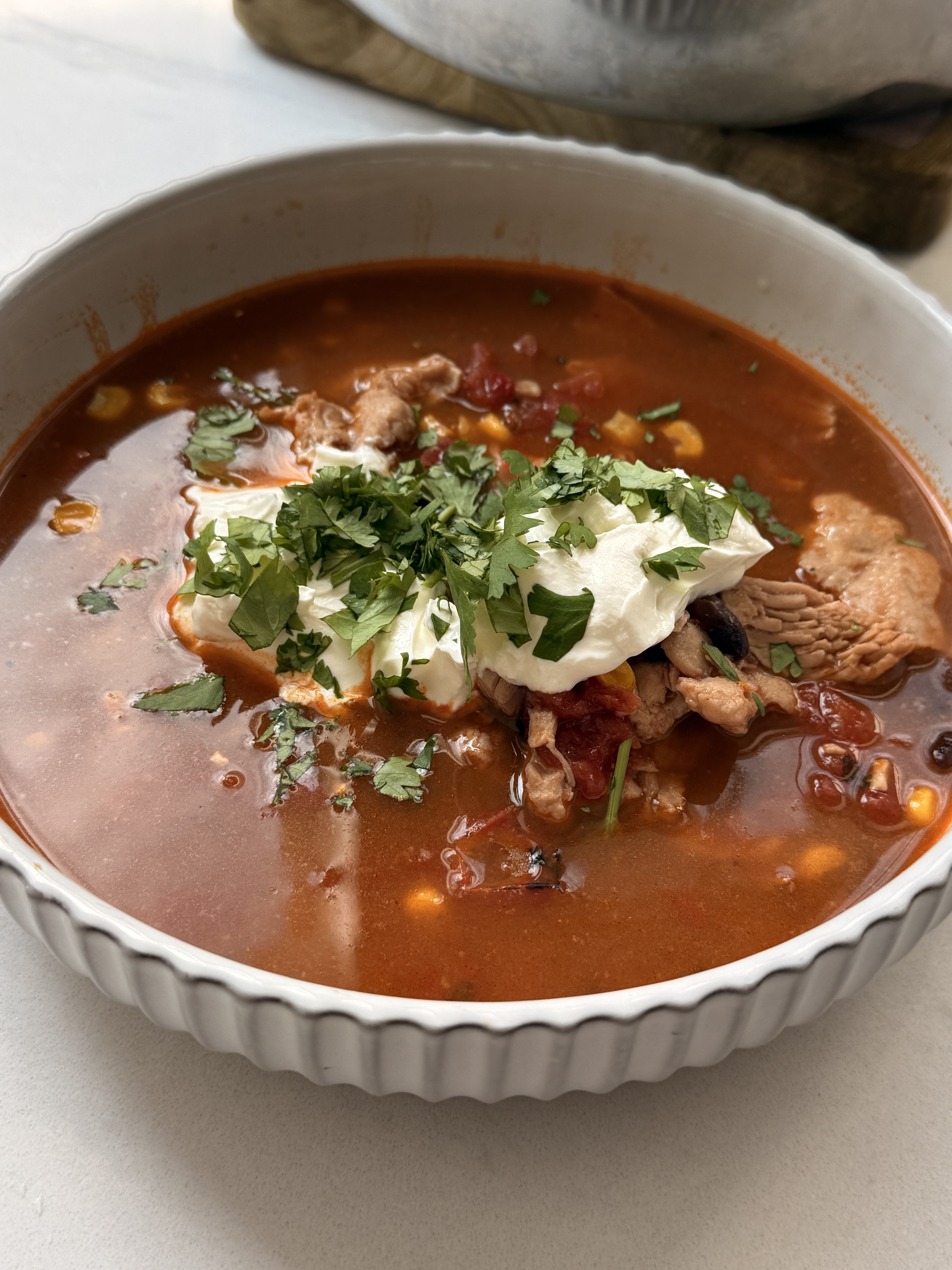 Overhead view of creamy butternut squash ravioli in a skillet with fresh sage and a golden sauce.
