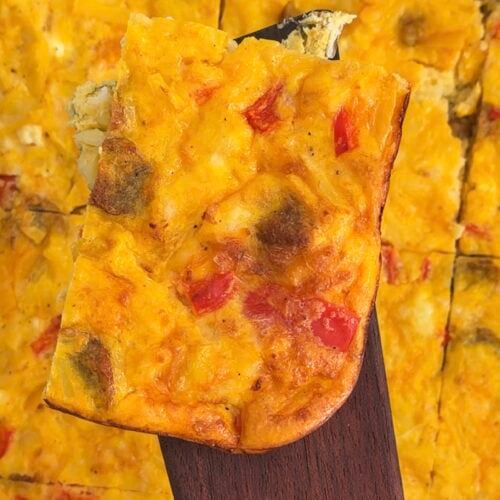 Maple sausage egg bake with cheddar and hashbrowns sliced in a baking dish