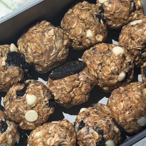 Cookies and cream lactation bites with crushed chocolate cookies and white chocolate chips in glass container