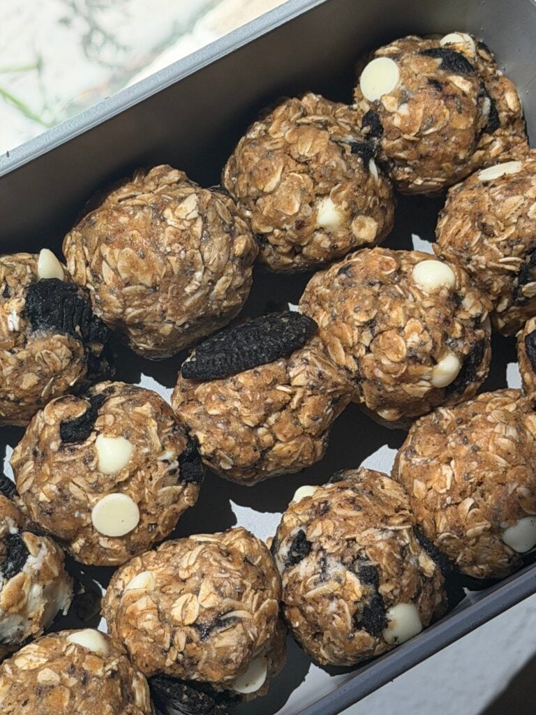 Cookies and cream lactation bites with crushed chocolate cookies and white chocolate chips in glass container