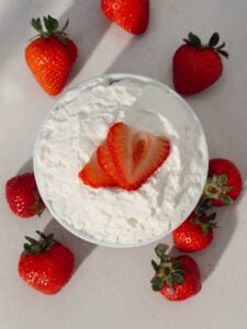Strawberry shortcake mug cake topped with macerated strawberries and whipped cream