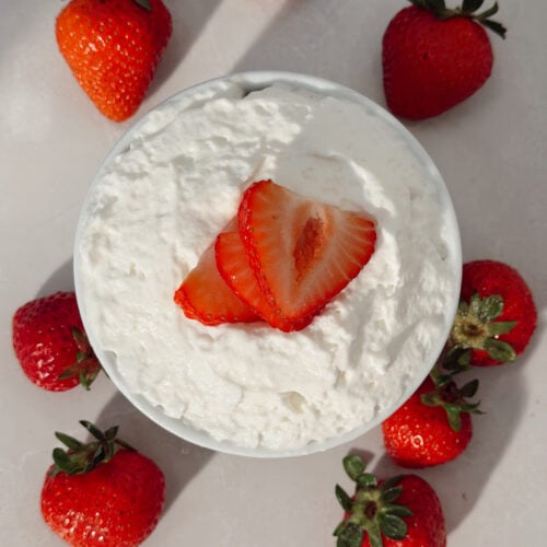 Strawberry shortcake mug cake topped with macerated strawberries and whipped cream